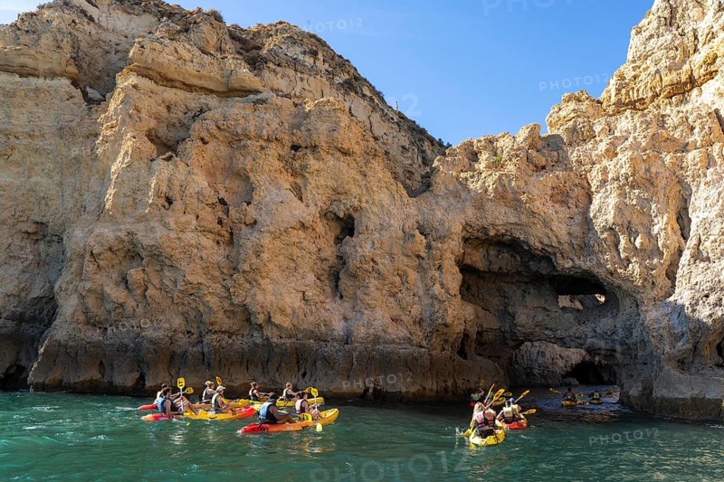 Tour with sea kayaks to the Ponta da Piedade rocky coast, rugged coastal landscape, right next to the city centre of Lagos, in the west of the Algarve, Portugal