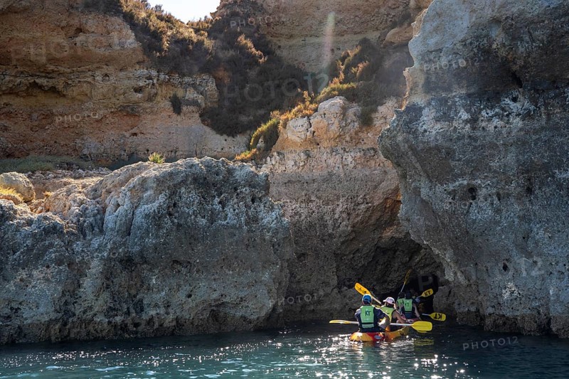 Tour with sea kayaks to the Ponta da Piedade rocky coast, rugged coastal landscape, right next to the city centre of Lagos, in the west of the Algarve, Portugal