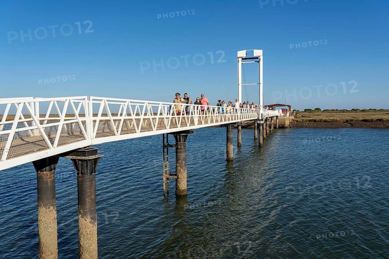 Bridge over the lagoon to the kilometre-long sandy beach Praia do Barril, on the island off Santa Luzia, Algarve, Portugal