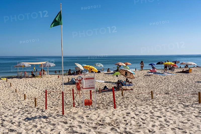 Kilometre-long sandy beach Praia do Barril, on the island off Santa Luzia, green flag indicates swimming permitted, lifeguards on the beach, Algarve, Portugal