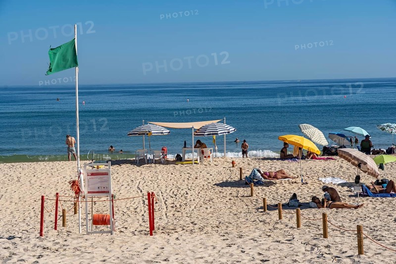 Kilometre-long sandy beach Praia do Barril, on the island off Santa Luzia, green flag indicates swimming permitted, lifeguards on the beach, Algarve, Portugal