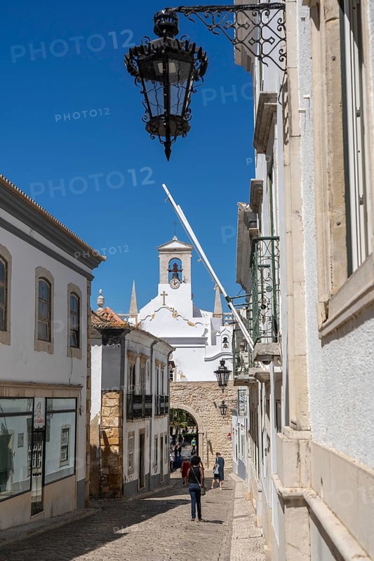 Faro, old town centre alley, R. do Municipio, view of the Arco da Vila city gate, Algarve, Portugal