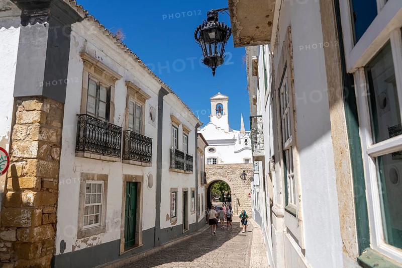 Faro, old town centre alley, R. do Municipio, view of the Arco da Vila city gate, Algarve, Portugal