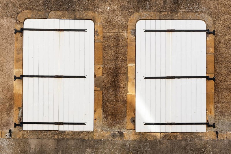 2 white, closed wooden windows, historic house façade, yellow sandstone, Marville, Renaissance village, Département Meuse, Grand Est, France