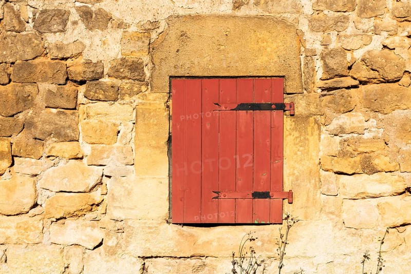Red wooden window, historic house façade, yellow sandstone, Marville, Renaissance village, Département Meuse, Grand Est, France