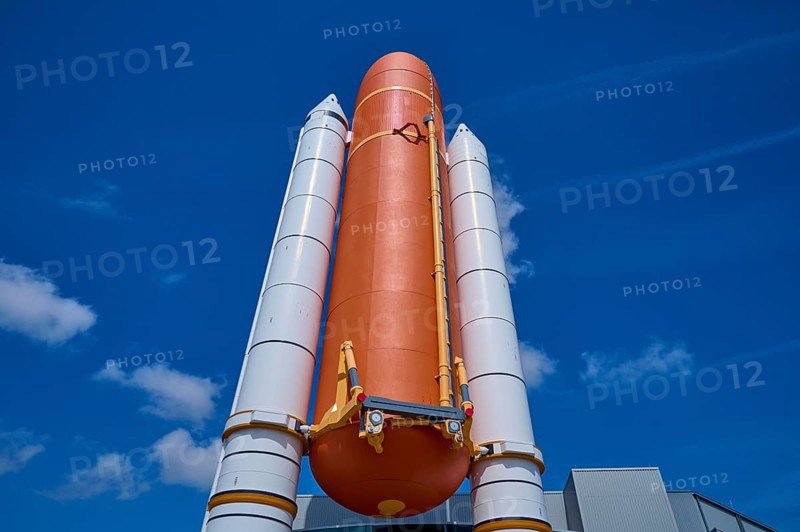 Large orange space shuttle with two launch vehicles against a blue sky, Kennedy Space Center Visitor Complex, Merritt Island, Florida, USA