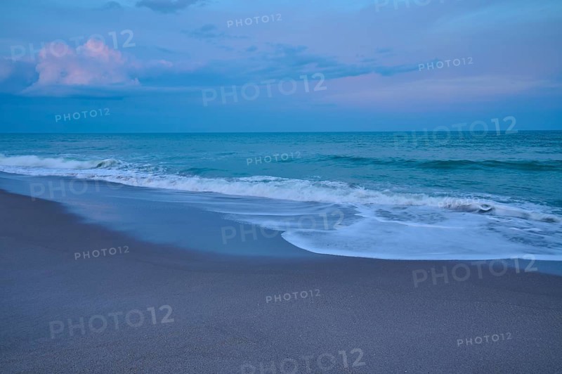 Beach at dusk with gentle waves and blue-grey sky, Cocoa Beach, Port Canaveral, Florida, USA