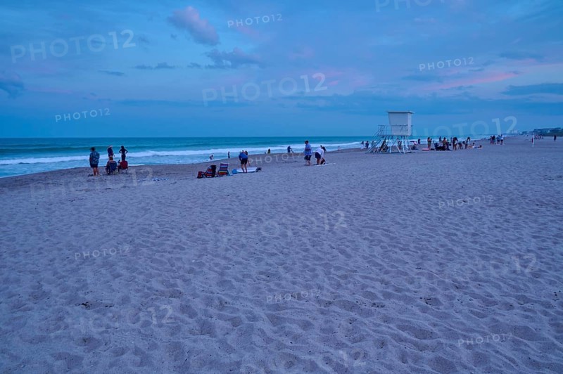 People enjoying the beach at dusk under a blue sky, Cocoa Beach, Port Canaveral, Florida, USA