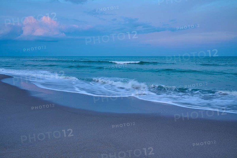 Beach scene with calming waves and blue evening sky, Cocoa Beach, Port Canaveral, Florida, USA