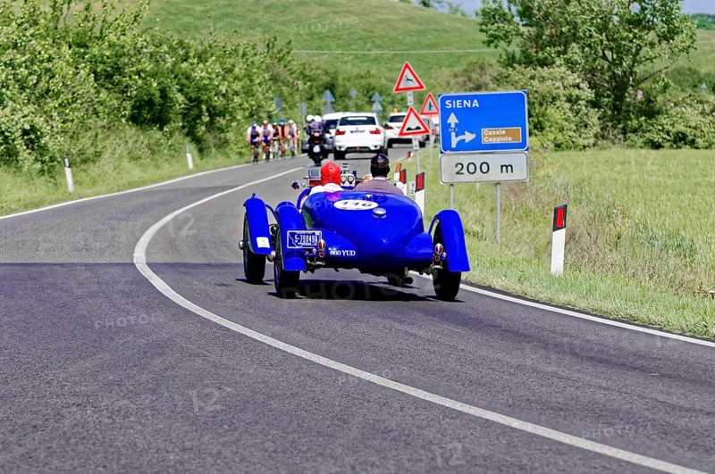 Blue classic car drives towards Siena, accompanied by other vehicles and signs, classic car, car race, Mille Miglia, 1000 Miglia, 2015, Tuscany, Rome Lake Garda, Italy