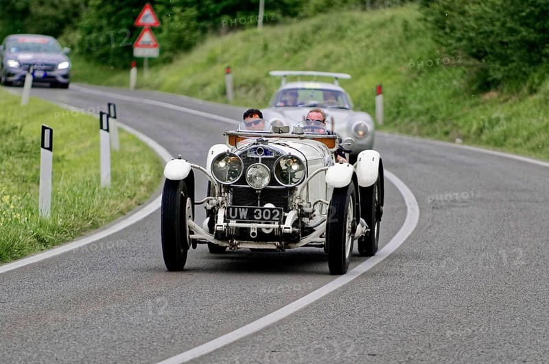 White classic car drives along a winding country road through a green landscape, classic car, car race, Mille Miglia, 1000 Miglia, 2015, Tuscany, Rome Lake Garda, Italy