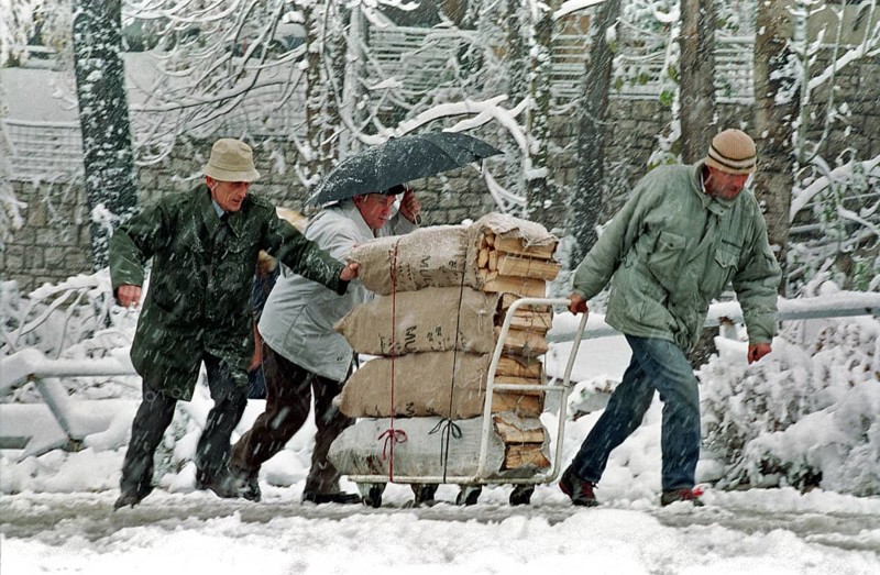 BIH, Bosnia, Sarajevo, 28.11.1993, People push a wagon with firewood through the snow