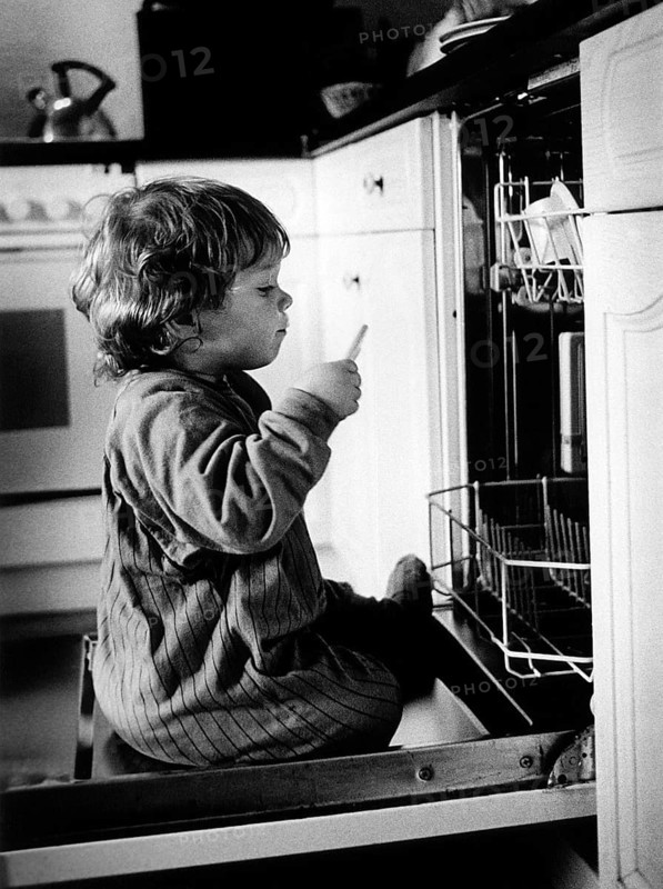 DEU, Meudt, 10.09.1999 -- From the series -- LINUS --- Linus on the dishwasher door. (dishwasher, curiosity)   (demography, child)