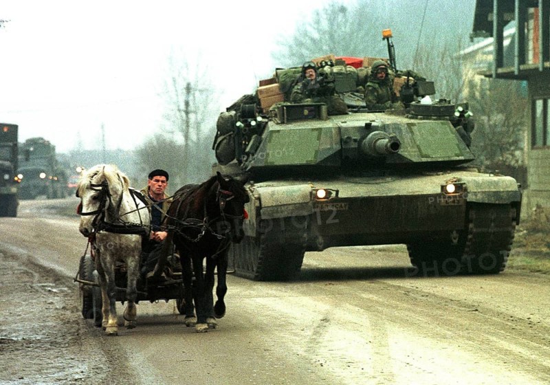 BIH, Tuzla, 01.01.1996 -- An American Abraham tank overtakes a Bosnian carriage near Tuzla. -- American Abraham tanks passing a horse-drawn carriage near their base at Tula airport.   Bosnia Hercogovina, Eastern Europe