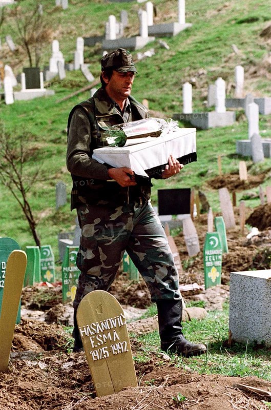 BIH, Bosnia, Tuzla, 07.05.1993 A Bosnian soldier is burying a child's coffin. The toddler was crushed in an overcrowded truck while fleeing from Srebrenica