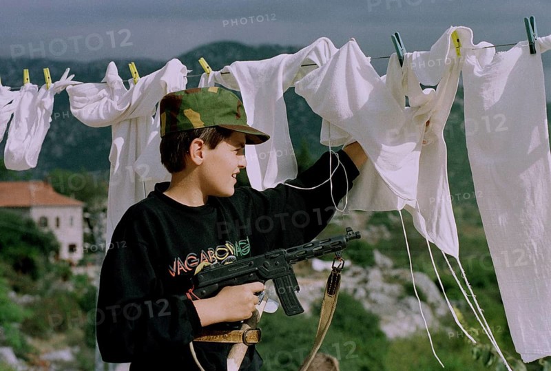 HRV, Kraotien, Dubrovnik 20.09.1993 Child with toy gun behind laundry. HRV Croatia, Dubrovnik, 1993 09 20 Kid with Toygun Behind Laundry