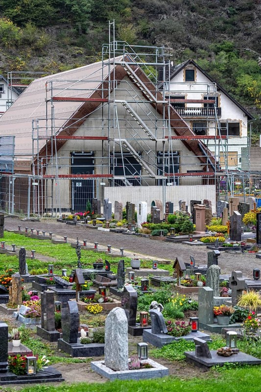 Reconstruction in the Ahr Valley, after the flood of July 2021, buildings that have not yet been renovated or demolished can be found in many places, but most buildings have now been repaired or rebuilt, restored cemetery, new cemetery hall under construction, near Altenahr, Rhineland-Palatinate