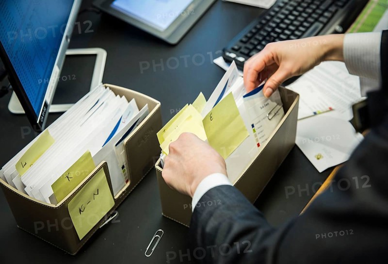 ITA Italy Castelfalfi An employee searches for invitations in front of an event in a hotel