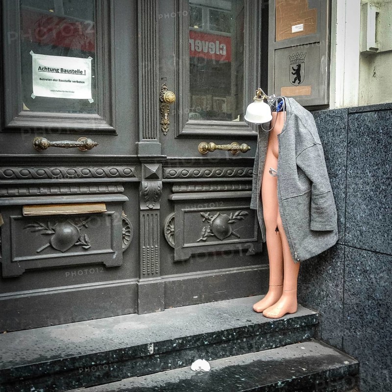 DEU Germany Germany Berlin Half a shop window doll is standing, decorated with lamp and mantle, in an entrance on Joachimsthaler Straße in Wilmersdorf