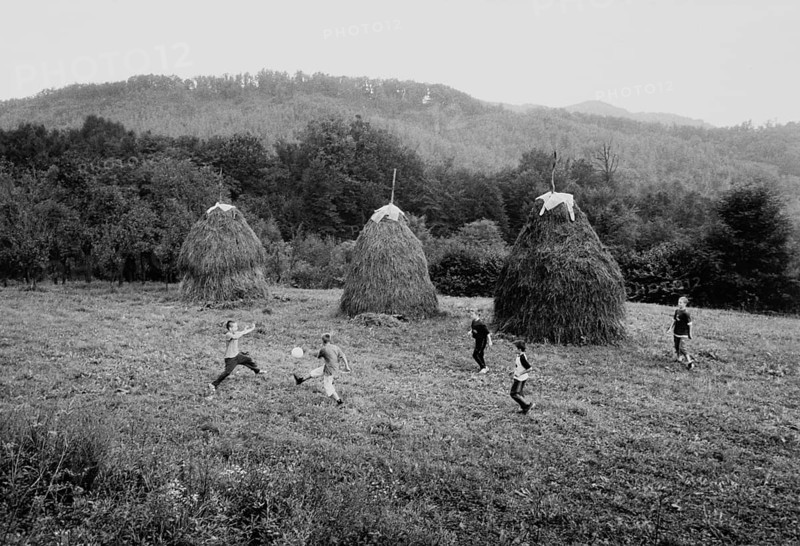 BIH, Bosnia, Tuzla, 05.10.2005, children playing soccer next to haystacks