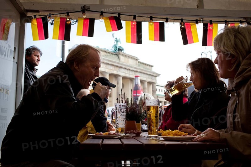 DEU Germany Berlin Eating and drinking in front of the Brandenburg Gate. Scene on the eve of the 20th anniversary of German reunification on the festival mile in Berlin. Germany Berlin People taking a snack in front of Brandenburg Gate. Scene from the public party one day ahead of the celebration marking the 20th anniversary of the German reunification