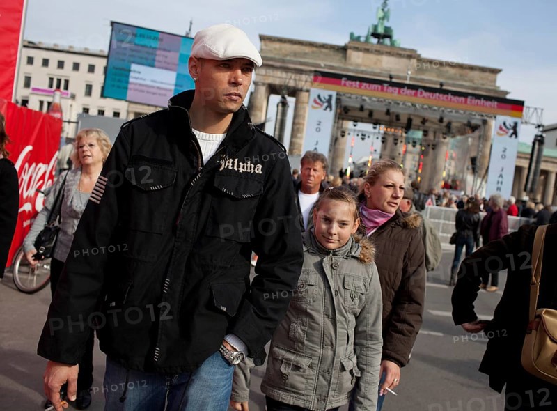 DEU Germany Berlin People stroll in front of the Brandenburg Gate. Scene on the eve of the 20th anniversary of German reunification on the festival mile in Berlin. Germany Berlin People Promenade in front of Brandenburg Gate. Scene from the public party one day ahead of the celebration marking the 20th anniversary of the German reunification