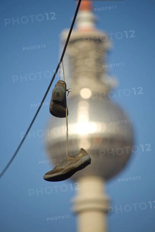 GERMANY Berlin shoes on a power line with a view of Alex. Germany Berlin Shoes are hanging over an electric wire near the TV Tower Alex