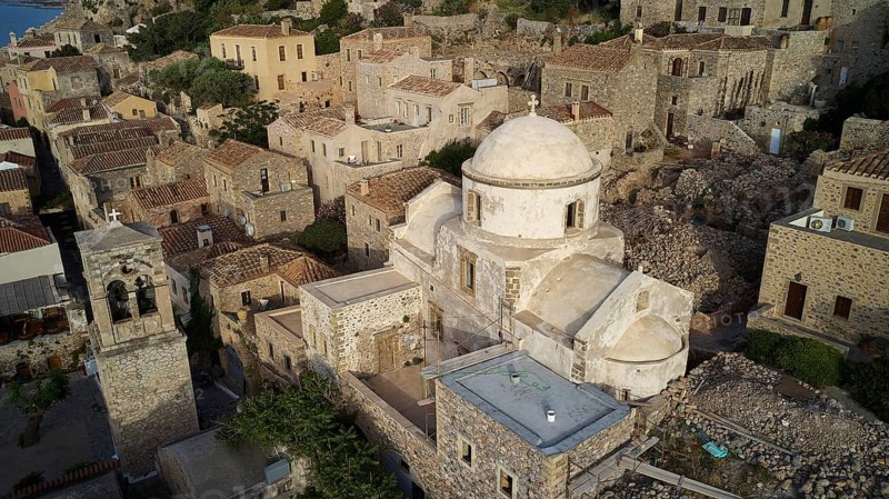 Drone view, aerial view of churches and stone houses in traditional village with vegetation, Monemvasia, Monemvassia, Malvasy, small Byzantine town, rocky island, fortress, Laconia, Peloponnese, peninsula, Greece