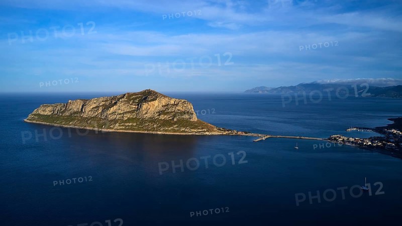 Drone shot, island in the sea, connected by bridge, mountains and sky in the background, Monemvasia, Monemvassia, Malvasy, small Byzantine town, rocky island, fortress, Laconia, Peloponnese, peninsula, Greece