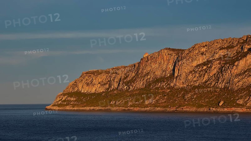 Orhodox church of Hagia Sophia, waterside rocks illuminated by evening sun under clear sky, Monemvasia, Monemvassia, Malvasy, Byzantine small town, rocky island, fortress, Laconia, Peloponnese, peninsula, Greece