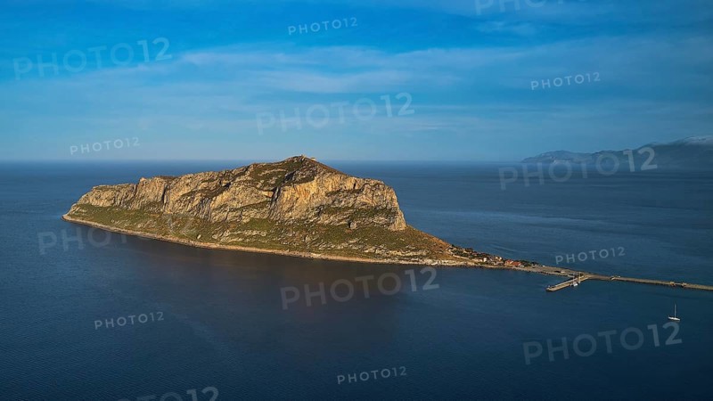 Drone shot, rocky island in calm sea under a blue sky, Monemvasia, Monemvassia, Malvasy, Byzantine small town, rocky island, fortress, Laconia, Peloponnese, peninsula, Greece