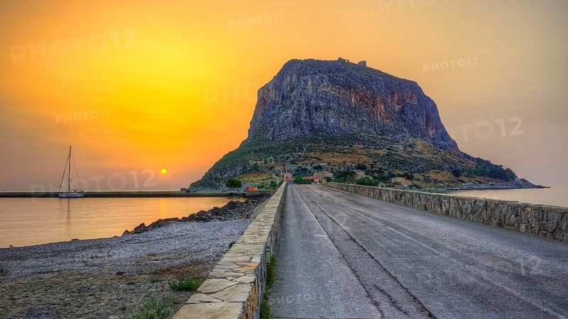 HDR road leads to an imposing mountain by the sea in the soft light of sunrise, Monemvasia, Monemvassia, Malvasy, small Byzantine town, rocky island, fortress, Laconia, Peloponnese, peninsula, Greece