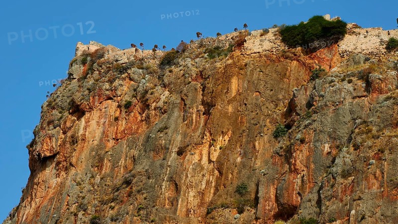 Soft morning light, spectacular cliffs with castle walls and distinct geological layers, Monemvasia, Monemvassia, Malvasy, Byzantine small town, rocky island, fortress, Laconia, Peloponnese, peninsula, Greece