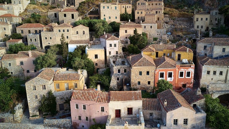 Drone shot, view of a colorful old town with densely packed houses and lush gardens, Monemvasia, Monemvassia, Malvasy, small Byzantine town, rocky island, fortress, Laconia, Peloponnese, peninsula, Greece