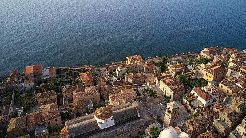 Drone shooting Sacred Church of Christ in Chains, Elkomenos Christos, Holy Church of the Virgin Mary Myrtidiotissa (or Critikias), drone shot, bird's eye view of a coastal village with traditional buildings and extensive sea views, Monemvassia, Malvasy, Byzantine small town, rocky island, fortress, Laconia, Peloponnese, peninsula, Greece