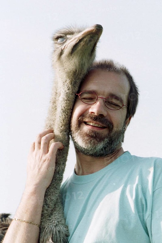 DEU, Mannheim, 22.07.1994 -- ostrich breeder (man, hug, bird ostrich, stroking, affection) -- Â© Karsten Thielker