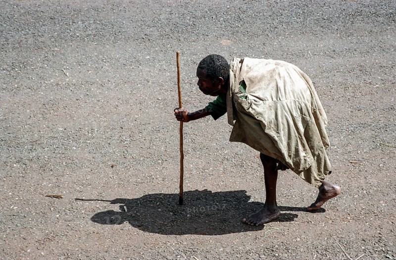 TZA Tanzania scene in the Benaco Camp refugee camp, to which up to 500, 000 Rwandan Tutsis fled the genocide in their country. The shadow of an old man with a stick resembles the stature of a Maasai warrior. TZA Tanzania Scene at the Benaco Camp, where an estimate of 500, 000 Rwandan Tutsi refugees fled the genocide in their country. The Shadow of a Man with a Walking Stick looks like the Statue of a Maasai Warrior