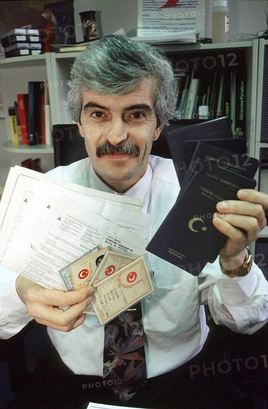 Berlin, DEU, 10.11.1998 -- portrait of Diyap Sarkalli holding Turkish passports and other documents. (bureaucracy, personal details) -- Â© Karsten Thielker