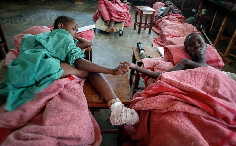 RWA Rwanda Kigali Injured Tutsi refugee children receive medical care in a makeshift hospital by doctors from Doctors Without Borders, MSF. They survived the genocide, which took the lives of 800, 000 people within 100 days. RWA Rwanda Kigali Injured Tutsi Refugee Kids in a Temporary Hospital Run by Doctors Without Borders