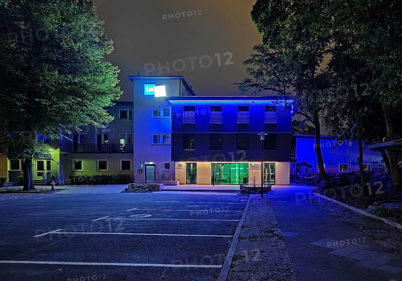 Blue-illuminated Berlin City Mission at night, Berlin, Germany