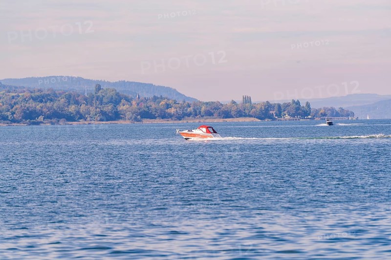 Two motorboats race across the water surface of a lake in a vast landscape, boat trip, Lake Constance, Germany