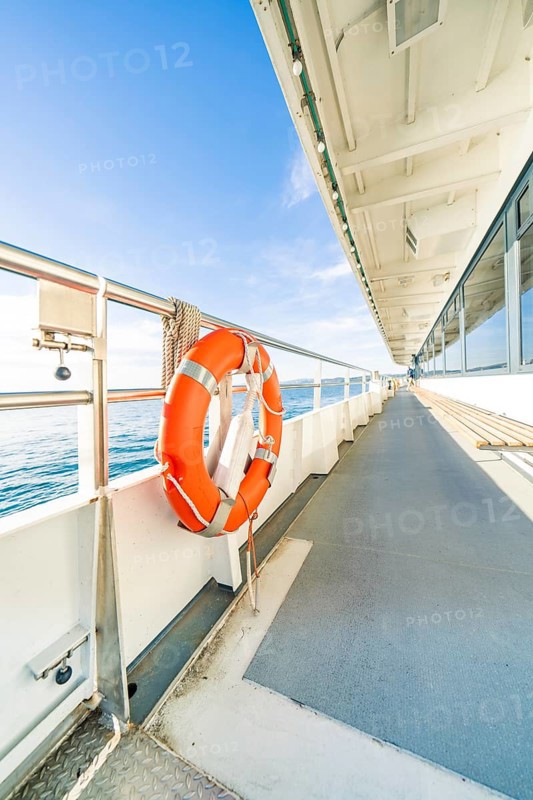 Side view from a ship deck with lifebuoy, calm sea and sunny sky, boat trip, Lake Constance, Germany