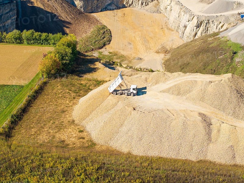A dump truck seen from the air on a pile of sand near a quarry, Nagold, Black Forest, Germany