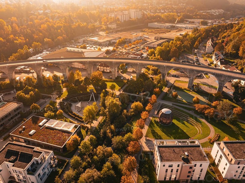 A viaduct within a city, surrounded by autumn-colored nature and modern buildings, Nagold, Black Forest, Germany