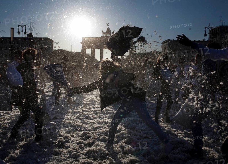 DEU Berlin It rains feathers during a pillow fight involving several hundred people at the Brandenburg Gate. Germany Berlin A flashmob battle with old pillows at Brandenburg Gate