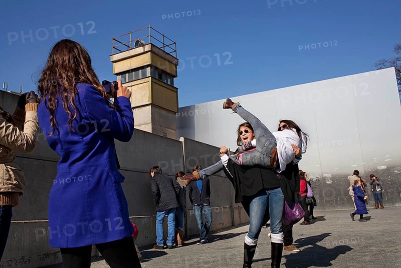 DEU Berlin Spanish tourists pose for photos at the Wall Memorial on Bernauer Straße in Berlin. Germany Berlin Spanish tourists stage pictures at the wall memorial at Bernauer Straße