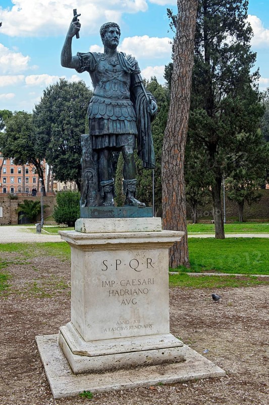 Statue of Emperor Hadrian on pedestal with inscription IMP for Emperor CAESARI HADRIANO AVG abbreviation for Augustus behind Castel Sant'Angelo Mausoleum Hadrian, Rome, Lazio, Italy