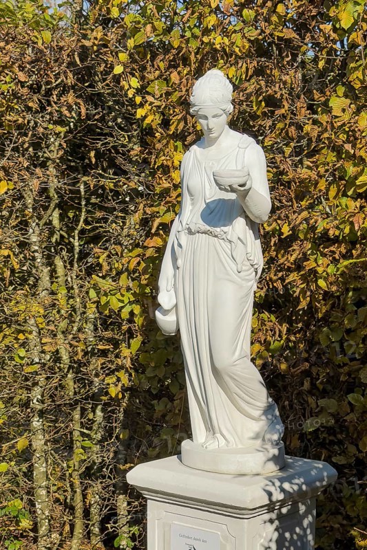 Statue of in Greek mythology goddess of youth Hebe Roman goddess Iuventas of male youth holding a sacrificial bowl in the garden of the open-air museum archaeological park Römische Villa Borg, Perl, Saarland, Germany