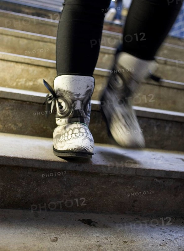 DEU Germany Germany Berlin Shoe with skull on a woman's feet at Friedrichsstraße train station