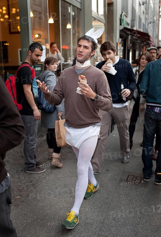 DEU Berlin tourist in bunny costume and doner kebab on Rosenthaler Straße in Berlin Mitte. He's having his bachelor party. Germany Berlin tourist wearing a bunny costums strolls along Rosenthaler Straße in Berlin Mitte